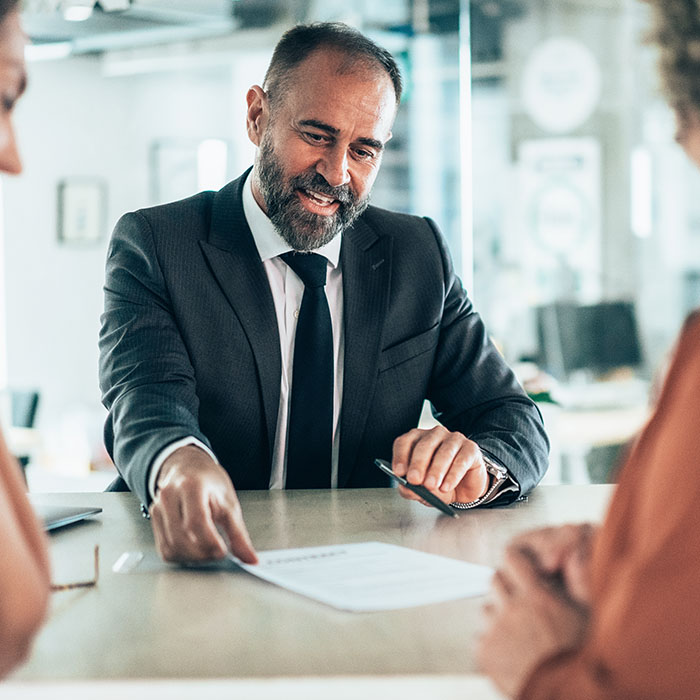 A team of professionals collaborates over a contract during a business meeting